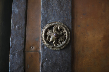 Bronze unicorn on a wooden door.