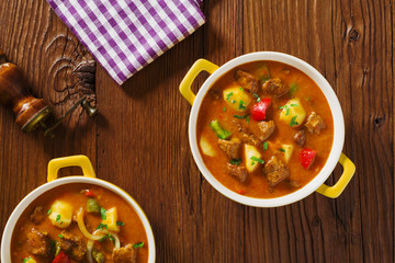Beef stew served with cooked potatoes.