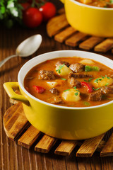Beef stew served with cooked potatoes.