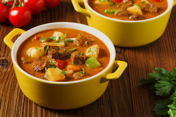 Beef stew served with cooked potatoes.