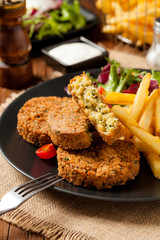 Serving of falafel and chips served on a black plate with sauce.