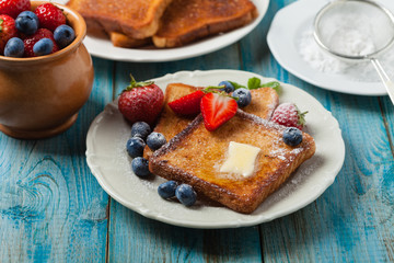 Traditional, delicious, sweet French toast with fruit and butter.