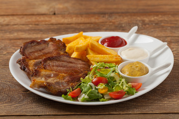 Grilled pork neck served with French fries and salad.