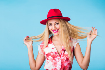 beauty fashion summer portrait of blonde woman with red lips and pink dress on blue background with copy space