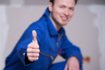 Handwerker auf einer Baustelle lächelt positiv in die Kamera 