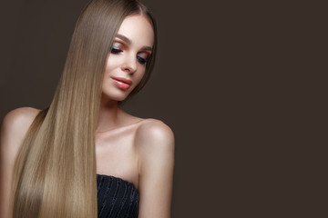 Beautiful blond girl with a perfectly smooth hair, classic make-up. Beauty face. Picture taken in...