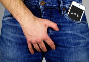 Young man with mobile phone in jeans pocket.Watch out for radiation.The cell phone radiation  harms...