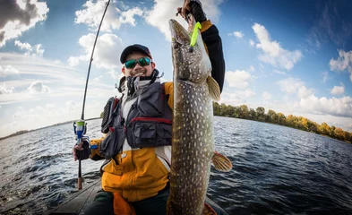 Fototapeten Fishing. Fisherman and trophy Pike. © vitaliy_melnik