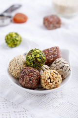 Healthy energy balls made of dried fruits and nuts with coconut chips, flax seeds, pistachios, sesame. Raw vegan candy.