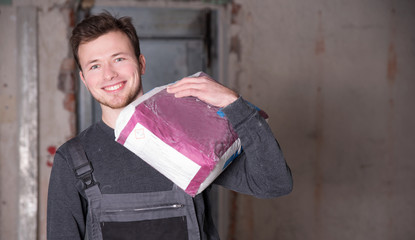 Arbeiter trägt einen Sack Zement 