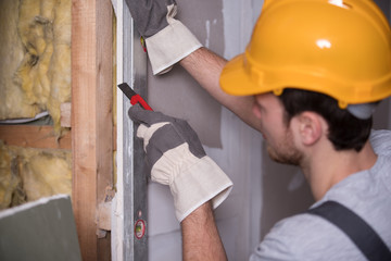 Handwerker schneidet Gpskarton-Platte, Trockenbau