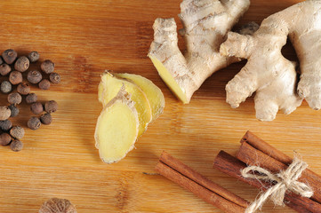 Pepper Jamaican fragrant, ginger root and cinnamon sticks on a light wooden board. Spices for giving food a taste and smell. Close-up. View from above. Macro photography.
