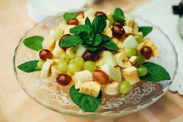 fruit mix on a plate of bananas, grapes and Apple for a healthy vegetarian diet