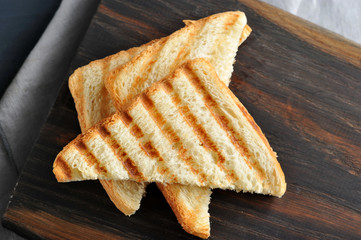 Several slices of fried white bread on a wooden board. Close-up. View from above. Macro photography.