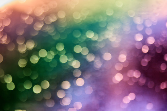 Defocused of multicolor LED light on black background. Bokeh photo of LED light. Green and purple. Orange and violet Bokeh. Iridescent blurred contrasted photo.