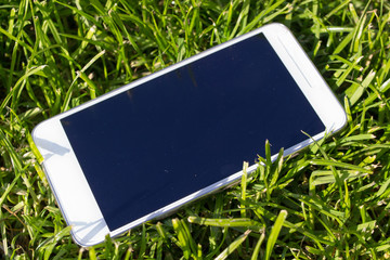 white smartphone on the grass