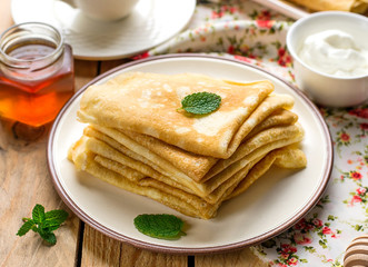 Stack of thin pancakes crepes bliny served with honey