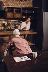 selective focus of young woman with cup of coffee and manikin at table in kitchen, perfect relationship dream concept