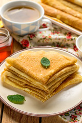Stack of thin pancakes crepes bliny served with honey