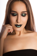Adorable young model with perfect skin and creative metallic green makeup. Closeup portrait at studio on a white background