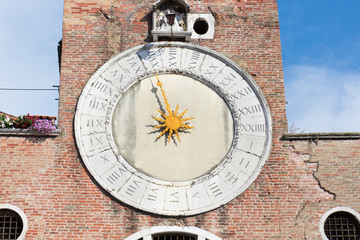 Fototapeta na wymiar Old clock on the facade of a tenement house in Venice