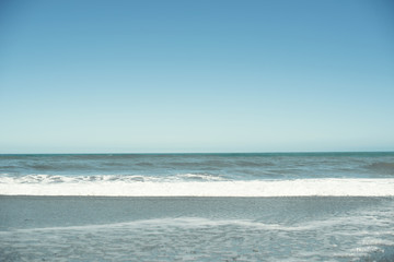 Paisaje de playa minimalista con un amplio cielo azul.