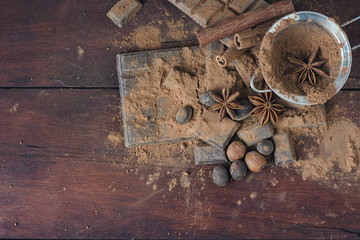 Chocolate, Spices, Spoon with Cocoa, Metal Strainer, Hazelnut on Dark Wooden Background. Copy space. Flat lay, top view