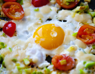 Freshly made scrambled eggs with tomatoes in a pan