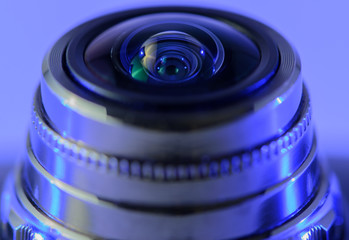 Close-up camera lens with blue backlight. Horizontal photo.