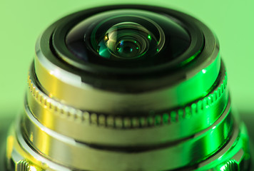 Fototapeta na wymiar Camera lens close - up backlit yellow-green. Horizontal photo..