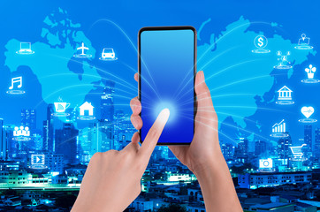woman hand using smartphone on internet of things and world map with blue night modern city background