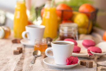 Breakfast with coffee cups, orange juice, makaron the outdoor terrace