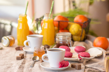 Breakfast with coffee cups, orange juice, makaron the outdoor terrace