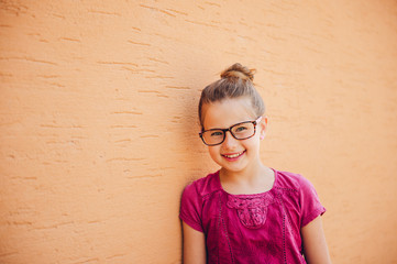 Outdoor portrait of adorable kid girl wearing glasses © annanahabed