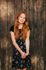Obraz na płótnie Canvas Outdoor fashion portrait of happy red-haired girl