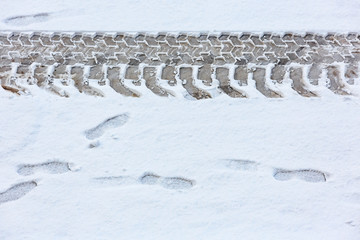 Traces of the tractor on the snow-covered road. View from above.