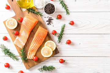 Raw salmon fillet with tomatoes lemon rosemary pepper and salt
