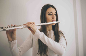 Young woman with flute. Female musician with her instrument performing.