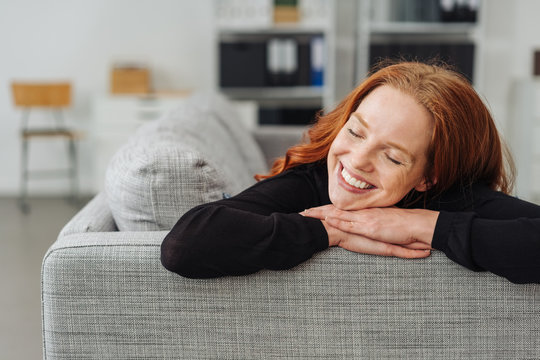 Young redhead woman reliving happy memories