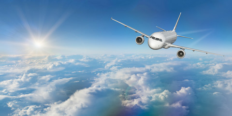 Commercial airplane flying above clouds.