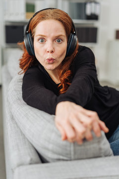 Young woman whistling as she listens to music