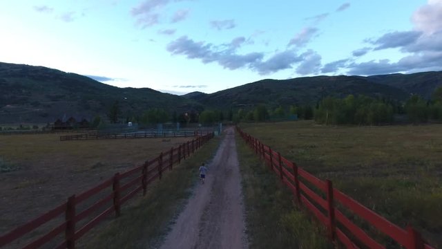 Boy running down a dirt road