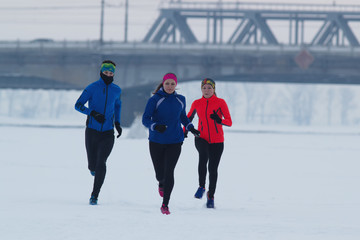 Group of young athletes running technically in winter forest