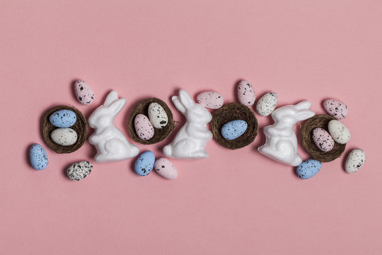 Easter background with easter eggs and easter bunnies on a pink background