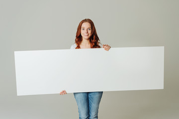 Young woman standing with blank white board