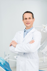 Fototapeta premium Confident doctor with folded arms in modern dental clinic