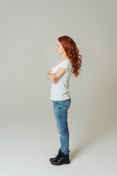 Young casual woman in jeans standing sideways