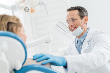 Smiling doctor consulting female patient in modern dental clinic