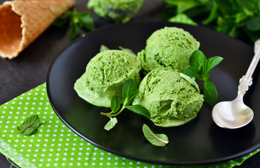 Ice cream with avocado, spinach on a black background. Summer dessert.