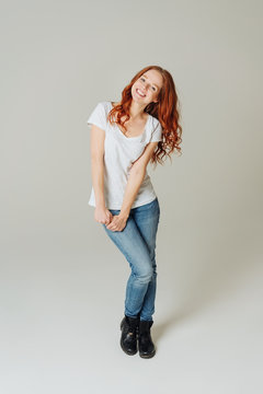 Cute happy young redhead woman in jeans